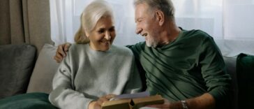 two grandparents holding a book sitting on a sofa